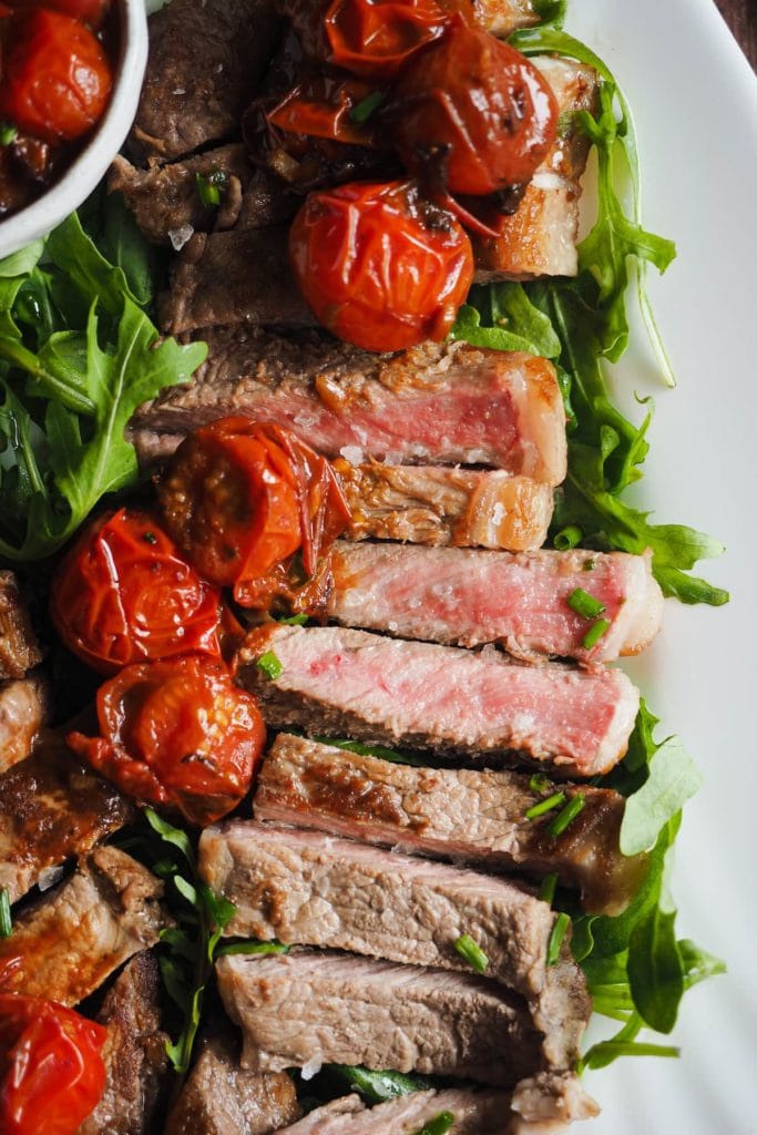 Entrecot con Tomates Cherry Asados. Foto de muy de cerca donde se aprecia la cocción al punto de la carne.