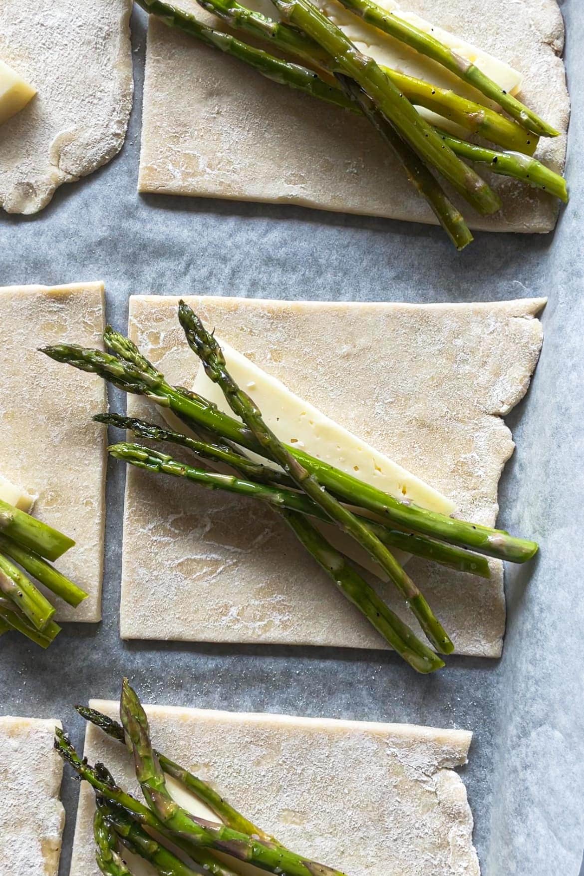 Hojaldre rápido casero con un trozo de queso encima y espárragos como relleno de los hojaldres. | Receta de Paula's Apron