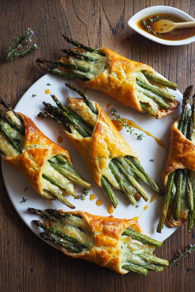 Hojaldres de Espárragos y Brie 100% caseros, fáciles de hacer y quedan perfectos como brunch, aperitivo, o entrante. Combinan un hojaldre casero rápido (¡en 5-10 minutos lo tienes listo!), con queso brie derretido y espárragos, que son un hit de temporada. Como broche, un toque de miel al tomillo que no puede ir mejor con el queso.¡Triunfa esta primavera! | Receta de Paula's Apron