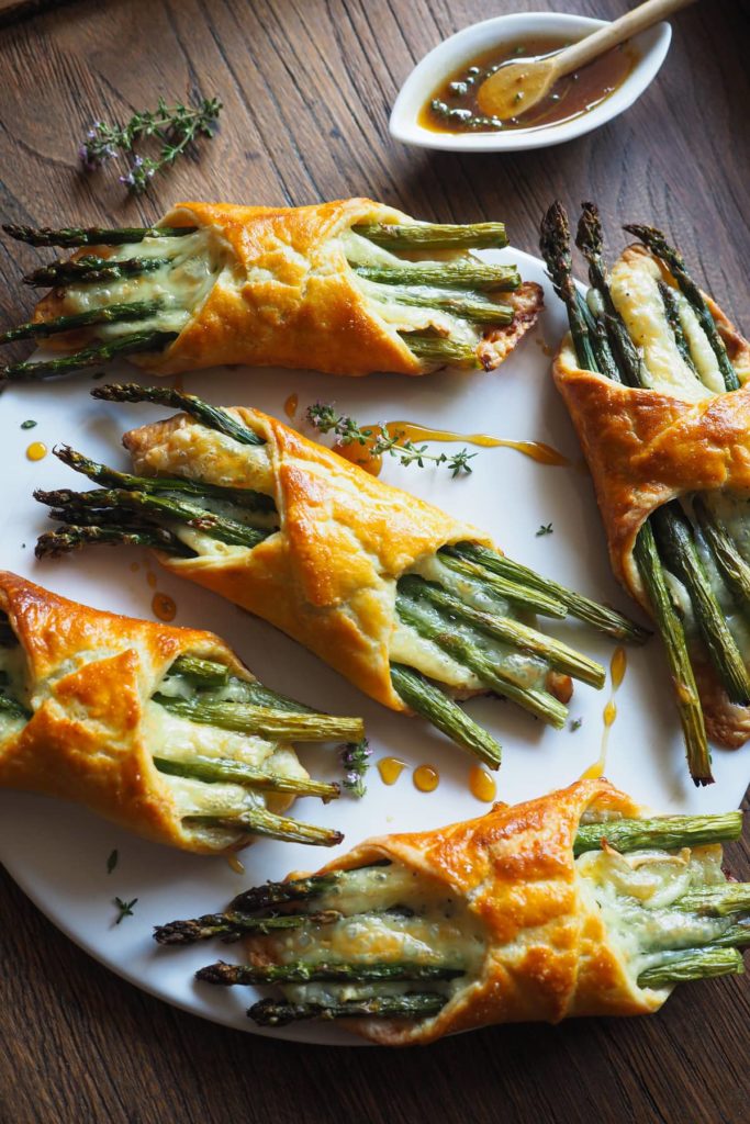 Hojaldres de Espárragos y Brie 100% caseros, fáciles de hacer y quedan perfectos como brunch, aperitivo, o entrante. Combinan un hojaldre casero rápido (¡en 5-10 minutos lo tienes listo!), con queso brie derretido y espárragos, que son un hit de temporada. Como broche, un toque de miel al tomillo que no puede ir mejor con el queso.¡Triunfa esta primavera! | Receta de Paula's Apron
