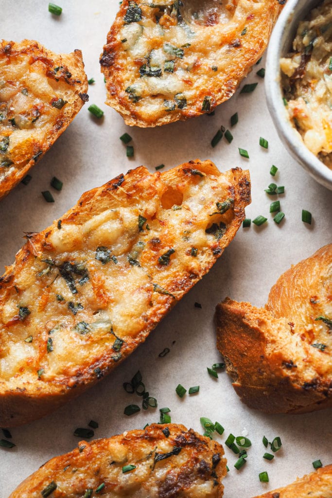 Pizza Style Garlic Confit Bread is a real crowd-pleaser. Good butter is mixed with fresh herbs, sundried tomato, cheese, and garlic. But not your average roasted garlic, confited garlic instead. It provides a gentle garlic flavour, so don't be afraid about your breath afterwards! It's perfect as an appetiser or side to accompany your soups and salads, your choice, but in any case, it will knock your socks off. | Paula's Apron Recipe