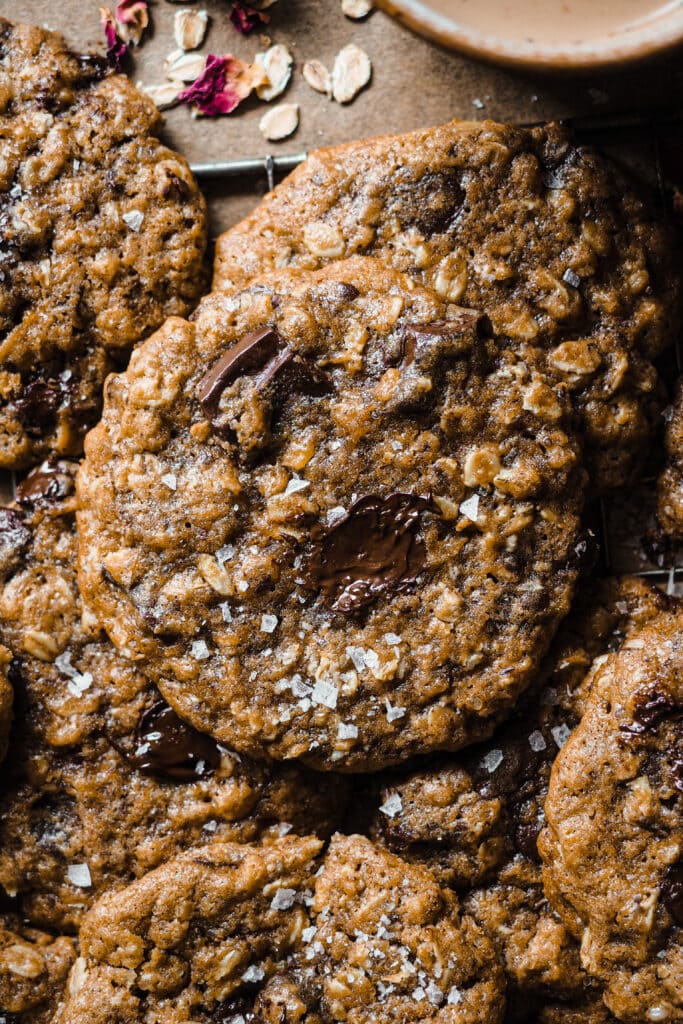 Estas Cookies de Avena y Chocolate con Mantequilla Tostada son una variación deliciosa de las clásicas cookies americanas. El toque de la avena aporta textura y lo que las hace aún más increíbles es el toque de mantequilla tostada con su aroma a frutos secos tostados. Quedan crujientes por fuera y blanditas por el centro, como una buena cookie (por eso no la llamo galleta como tal), y personalmente me encantan con un toque final de sal marina para ese contraste dulce-salado. | Receta de Paula's Apron