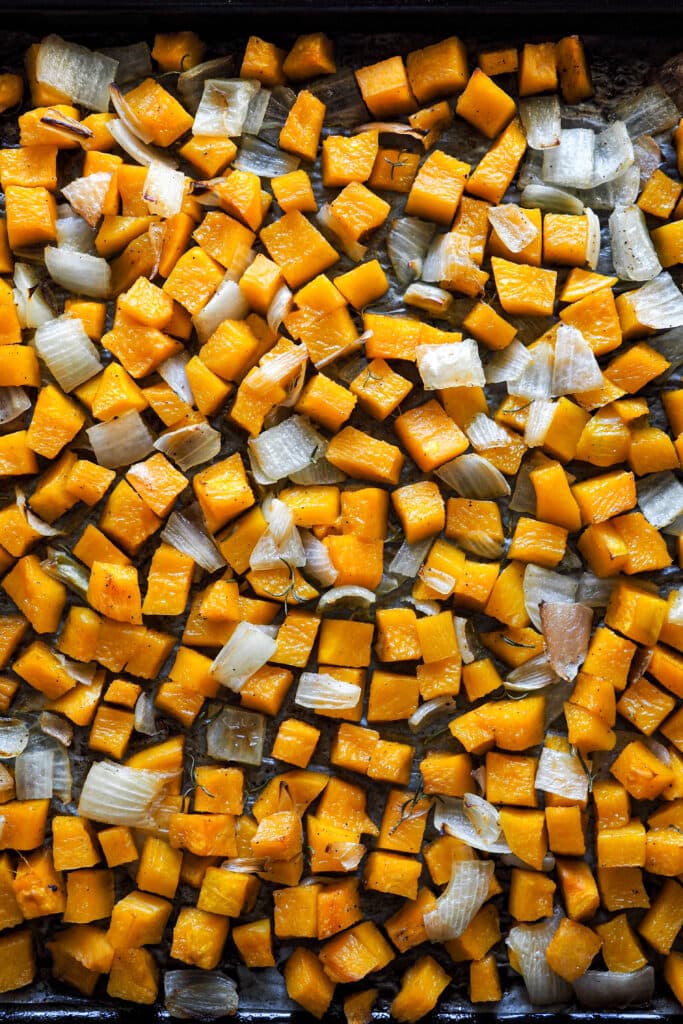 Calabaza y cebolla asadas con romero, sal y pimienta para hacer crema de calabaza. | Receta de Paula's Apron