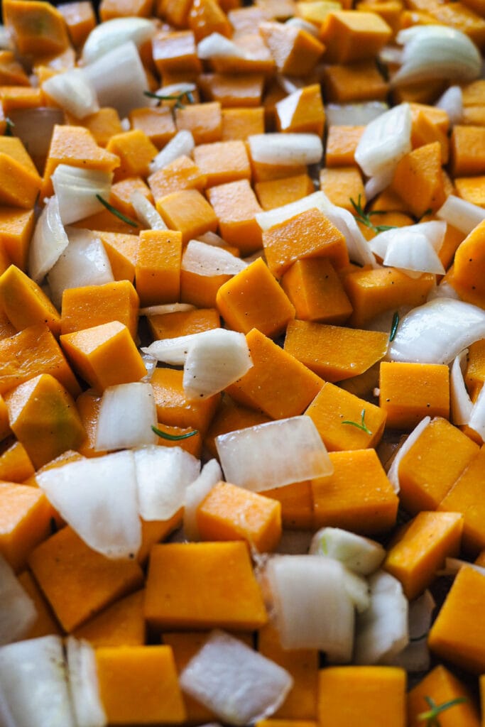 Calabaza y cebolla cortadas en trozos para hacer crema de calabaza. | Receta de Paula's Apron