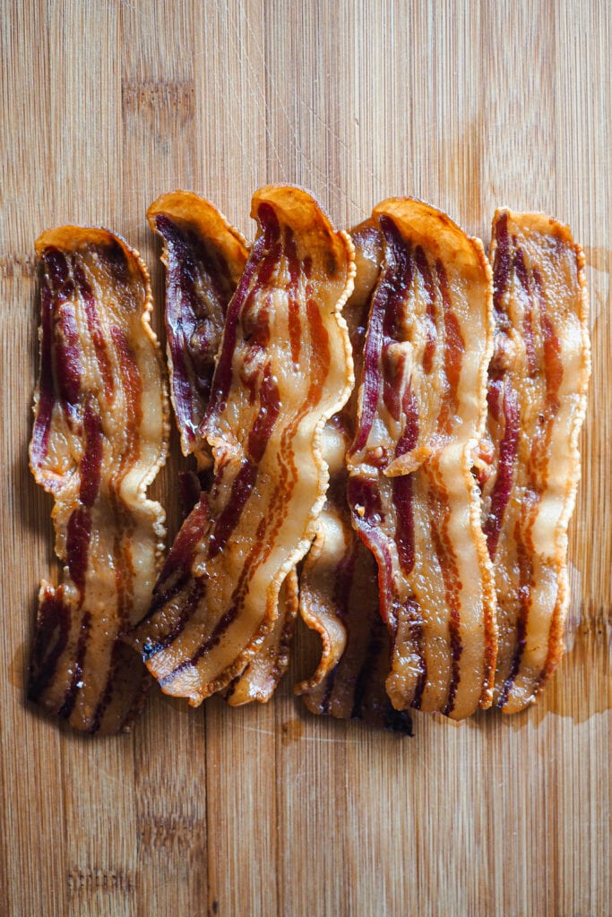 Panceta a tiras horneada sobre tabla de madera