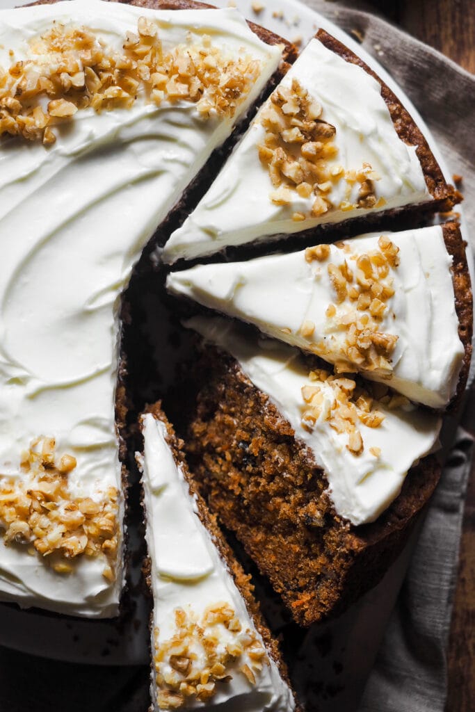 Este es el Mejor Carrot Cake para cualquier ocasión (o la Mejor Tarta de Zanahoria, lo llames como lo llames). Húmedo, sabroso y fácil de hacer, verás que no habrá quien no te pida un segundo trozo. Y es que gusta tanto a quien prefiere un carrot cake húmedo como al que no tan húmedo, al que lo quiere esponjoso y al que le gusta más denso, así que... Ya sea para una tarta de cumpleaños, un día festivo o simplemente porque sí, esta versión de tarta de zanahoria siempre triunfa. Yo hago tarta de zanahoria con nueces, pero puedes omitirlas si quieres. Su versatilidad y balance realmente la ha convertido en la mejor tarta de zanahoria para cualquier ocasión con cobertura de queso crema. | Receta de Paula's Apron