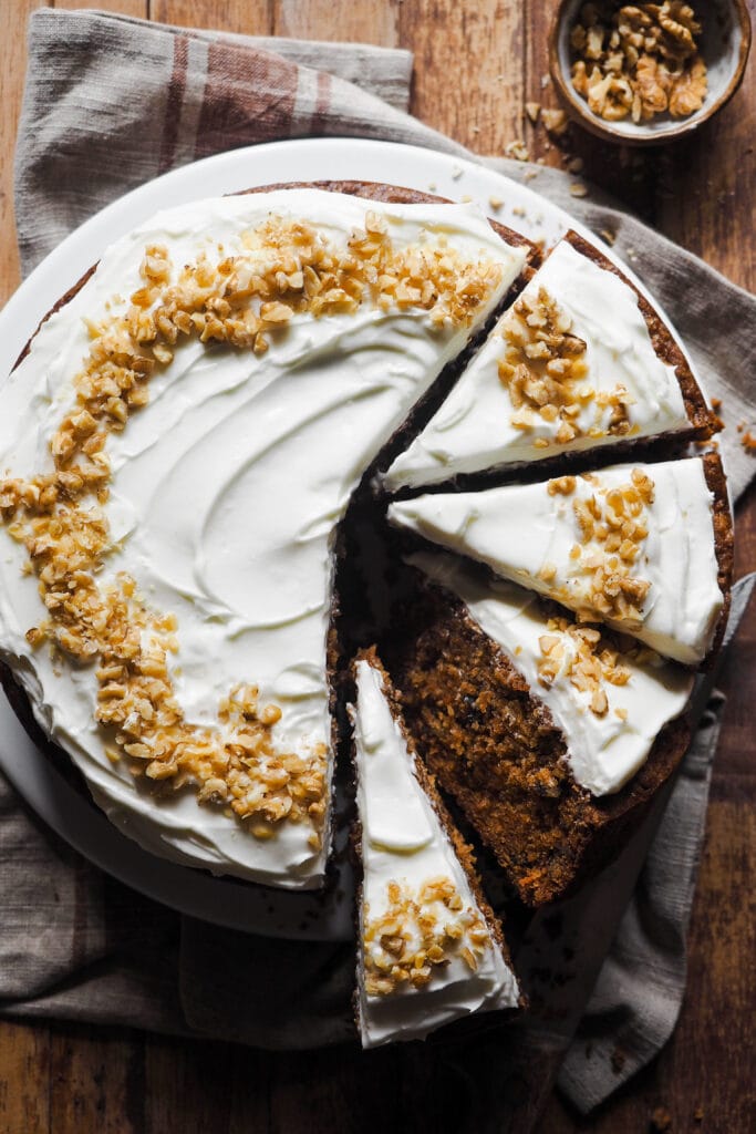 Este es el Mejor Carrot Cake para cualquier ocasión (o la Mejor Tarta de Zanahoria, lo llames como lo llames). Húmedo, sabroso y fácil de hacer, verás que no habrá quien no te pida un segundo trozo. Y es que gusta tanto a quien prefiere un carrot cake húmedo como al que no tan húmedo, al que lo quiere esponjoso y al que le gusta más denso, así que... Ya sea para una tarta de cumpleaños, un día festivo o simplemente porque sí, esta versión de tarta de zanahoria siempre triunfa. Yo hago tarta de zanahoria con nueces, pero puedes omitirlas si quieres. Su versatilidad y balance realmente la ha convertido en la mejor tarta de zanahoria para cualquier ocasión con cobertura de queso crema. | Receta de Paula's Apron