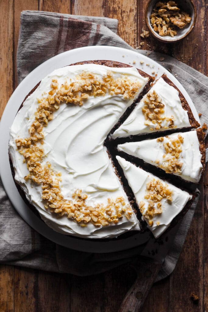 Este es el Mejor Carrot Cake para cualquier ocasión (o la Mejor Tarta de Zanahoria, lo llames como lo llames). Húmedo, sabroso y fácil de hacer, verás que no habrá quien no te pida un segundo trozo. Y es que gusta tanto a quien prefiere un carrot cake húmedo como al que no tan húmedo, al que lo quiere esponjoso y al que le gusta más denso, así que... Ya sea para una tarta de cumpleaños, un día festivo o simplemente porque sí, esta versión de tarta de zanahoria siempre triunfa. Yo hago tarta de zanahoria con nueces, pero puedes omitirlas si quieres. Su versatilidad y balance realmente la ha convertido en la mejor tarta de zanahoria para cualquier ocasión con cobertura de queso crema. | Receta de Paula's Apron