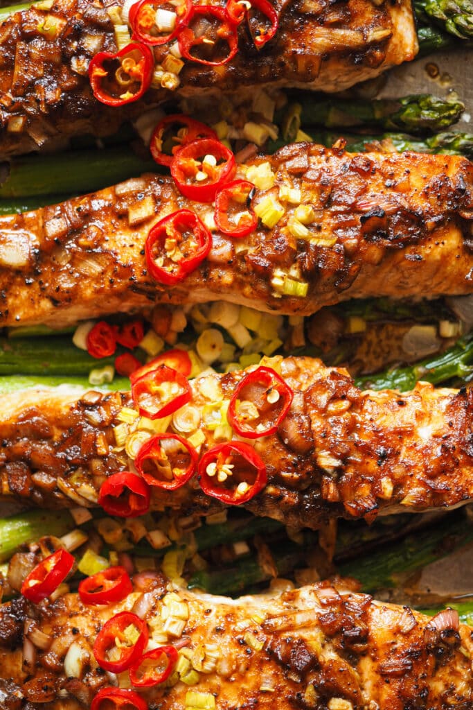 Este Salmón al Horno con Espárragos y Vinagreta de Miel y Limón es fresco, ligero, fácil de hacer y nutritivo, ¡lo tiene todo! El salmón se marina con una vinagreta deliciosa que mezcla un toque ácido con dulce y salado. Luego se cocina todo junto en una bandeja de horno y terminamos con un topping de chile y cebolleta. Sírvelo con arroz o puré de patatas y tienes un plato completo para una comida saludable, o acompáñalo de ensalada si quieres algo más light para la cena. ¡Una delicia! | Receta de Paula's Apron