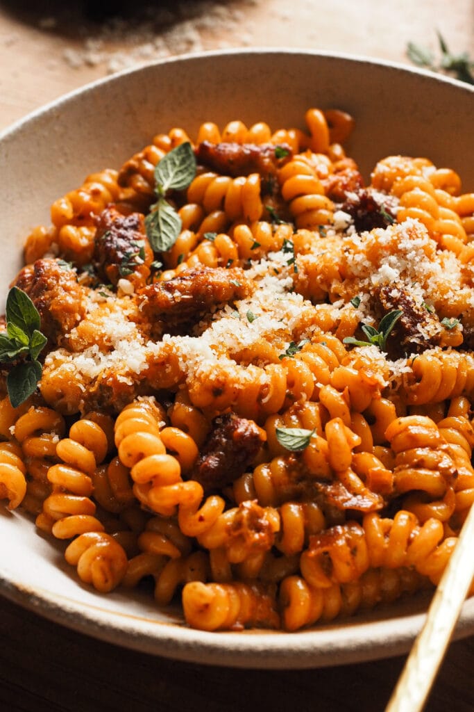 Esta no es la clásica Pasta alla Vodka, sino, me atrevería a decir, su versión mejorada: Pasta alla Vodka con Pesto y Salchicha (y, si eres vegetariano, omitimos la salchicha y listos). Tienes este platazo de pasta listo en menos de 30 minutos y encima es ideal para hacerlo en modo batchcooking (al día siguiente hasta está más rico). Ya sea para un día de cada día, para el fin de semana, un festivo o para cuando tengas invitados, con esta pasta siempre vas a dejar a todo el mundo queriendo repetir. | Receta de Paula's Apron
