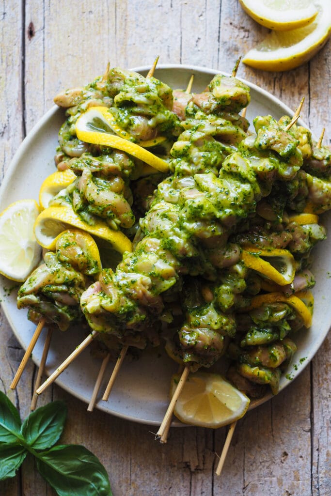 Brochetas de Pollo Asado con Salsa Verde Multiusos perfectas para el buen tiempo. Aquí ves el pollo ensartado en brochetas con algunas rodajas de limón intercaladas. | Receta de Paula's Apron