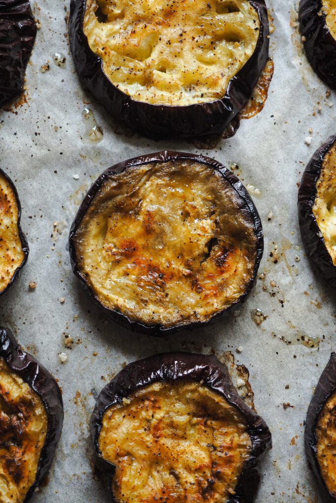 Berenjena asada en rodajas con sal y pimienta negra.