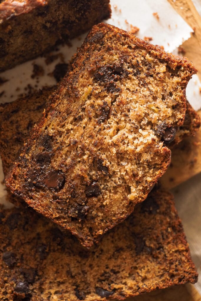 Banana Bread con Mantequilla Tostada húmedo y esponjoso. La mantequilla tostada le aporta un toque como de frutos secos que lo hace más especial sin complicaciones y también le he añadido chocolate y canela porque, a parte de ir genial con el plátano, me parecen unos extras muy otoñales, pero son totalmente opcionales. Además, es un bizcocho de plátano fácil, no necesitas batidor eléctrico y todo se mezcla en un único bol. ¡Ya verás que si lo pruebas volverás a él una y otra vez! | Receta de Paula's Apron