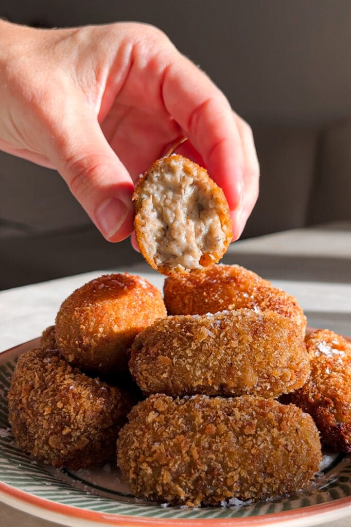 Croquetas de Setas cremosas por dentro y crujientes por fuera, con un increíble sabor umami gracias al boletus. Tamnbién llevan champiñones y te explico como hacer la bechamel perfecta para que no queden grumos. Estas croquetas son un homenaje al otoño e ideales para un buen picoteo o aperitivo. En esta foto se puede apreciar la capa perfecta de rebozado con panko crujiente e interior cremoso. | Receta de Paula's Aspron