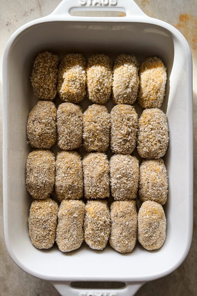 Croquetas de Setas formadas y en una bandeja para ser cocinadas. Quedan cremosas por dentro y crujientes por fuera, con un increíble sabor umami gracias al boletus. Tamnbién llevan champiñones y te explico como hacer la bechamel perfecta para que no queden grumos. Estas croquetas son un homenaje al otoño e ideales para un buen picoteo o aperitivo. | Receta de Paula's Aspron