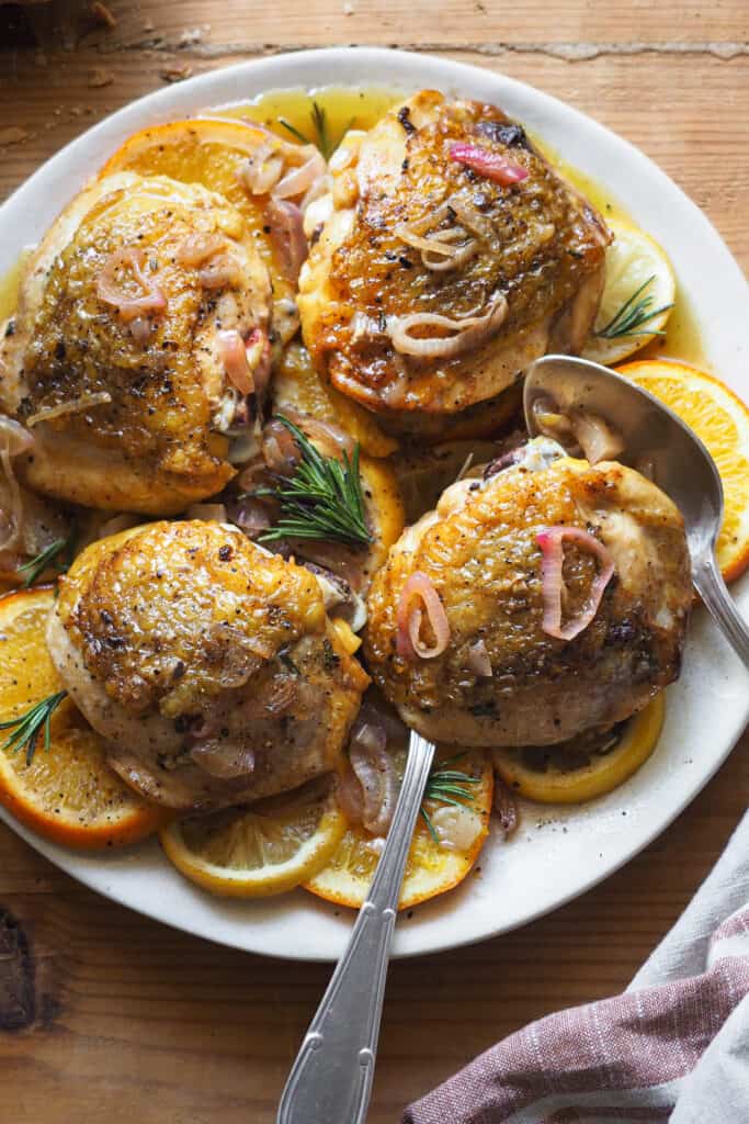 Esta receta fácil y deliciosa de Pollo Asado al Limón y Naranja es perfecta para una comida reconfortante. El pollo queda tierno, jugoso y con un sabor cítrico y a hierbas increíble. Preparada con contramuslos, lista en poco más de media hora e ideal para ajustar las cantidades según el número de comensales. ¡Estos contramuslos de pollo asados al limón y naranja son una opción rápida y deliciosa para cualquier ocasión! | Receta de Paula's Apron