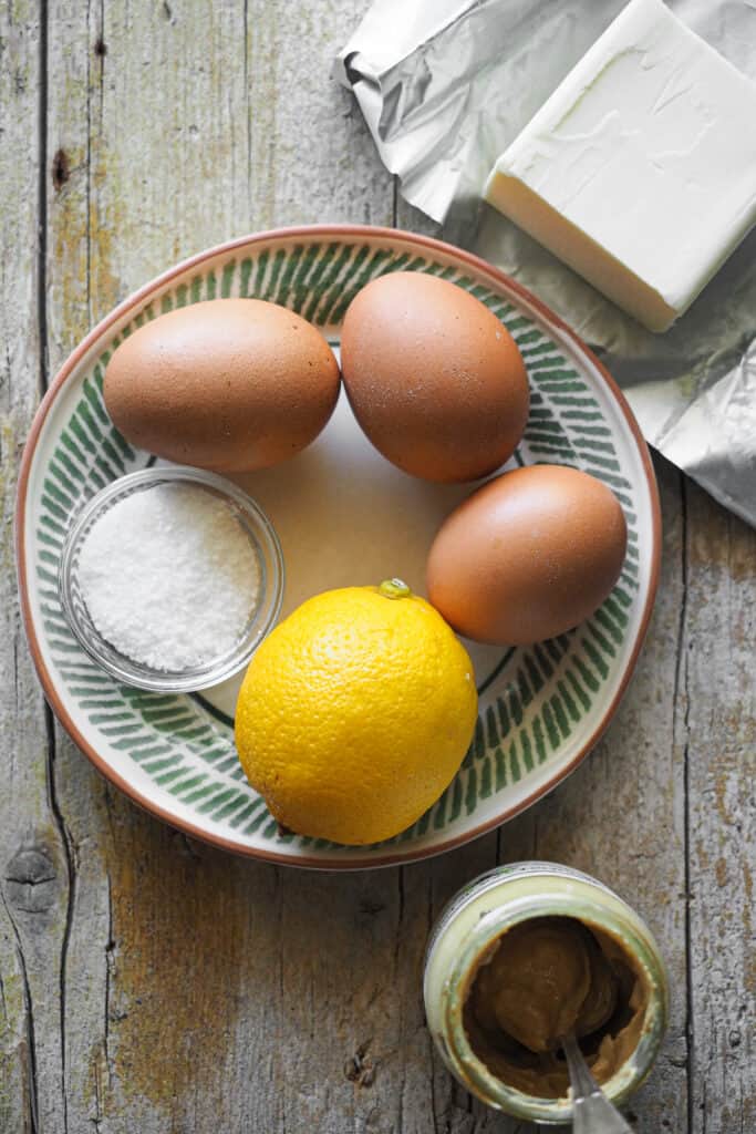 Ingredientes para hacer Salsa Holandesa Rápida y Fácil: huevos, mantequilla, limón y sal más condimentos al gusto (yo uso mostaza).