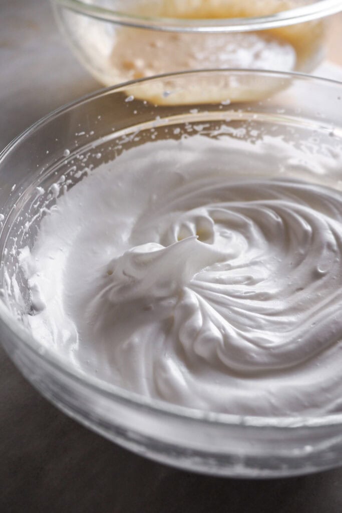 Claras montadas a punto de nieve en un bol de cristal para hacer una torta tenerina.