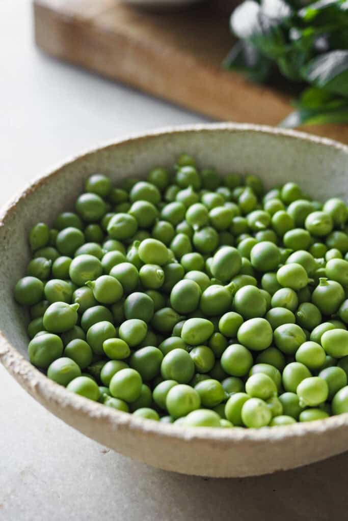 Bol con guisantes frescos para añadir a ñoquis con pesto