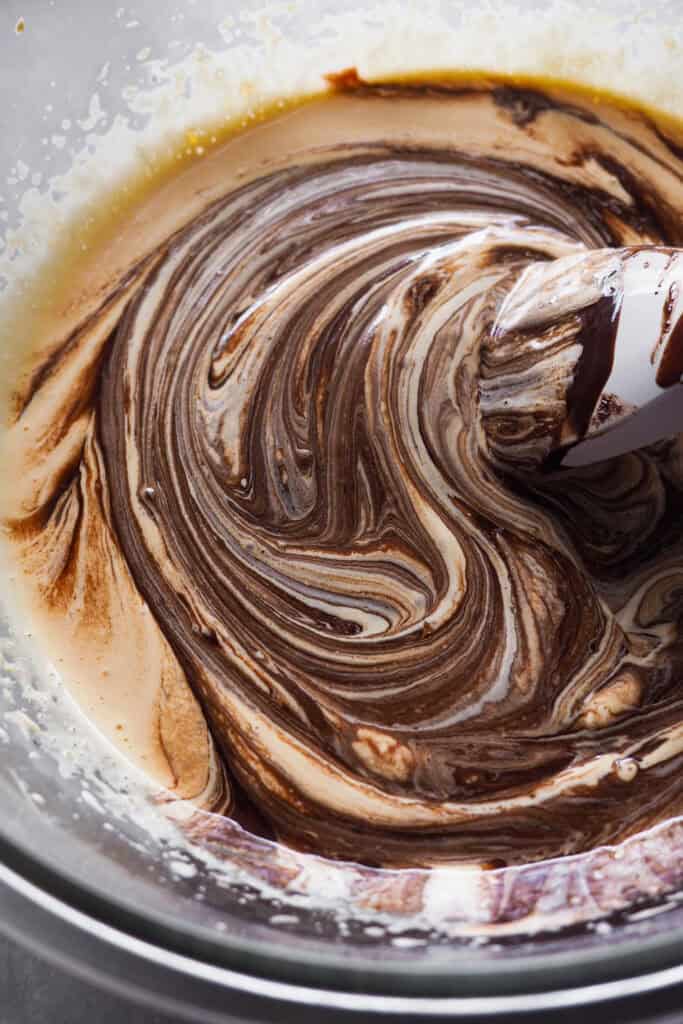 Masa para torta tenerina en un bol de cristal con una espátula dentro.