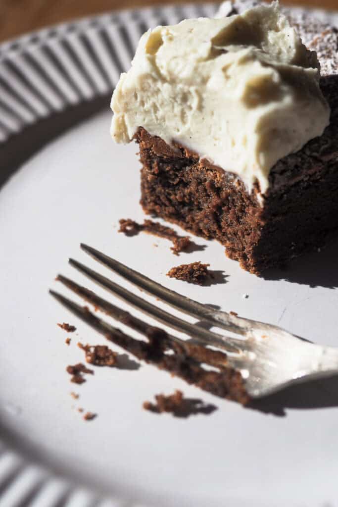 Torta Tenerina! Un clásico italiano, esta tarta de chocolate se caracteriza por su textura densa y húmeda en el interior parecida a un brownie y una superficie crujiente. Es perfecta para cualquier ocasión, sencilla de preparar con solo 5 ingredientes pero impresionante en su sabor y presentación. Acompañada de una suave crema de mascarpone, se convierte en el postre ideal para compartir con familia y amigos. ¡Anímate a probar este delicioso postre italiano! | Receta de Paula's Apron