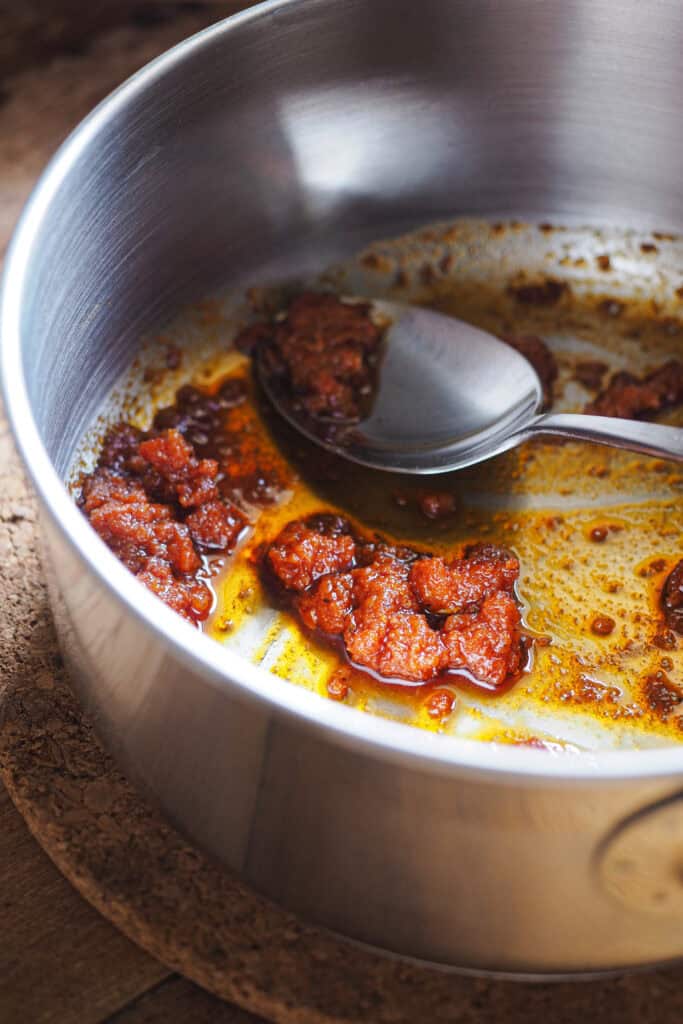 Sobrasada sudada en cazo pequeño de acero inoxidable.