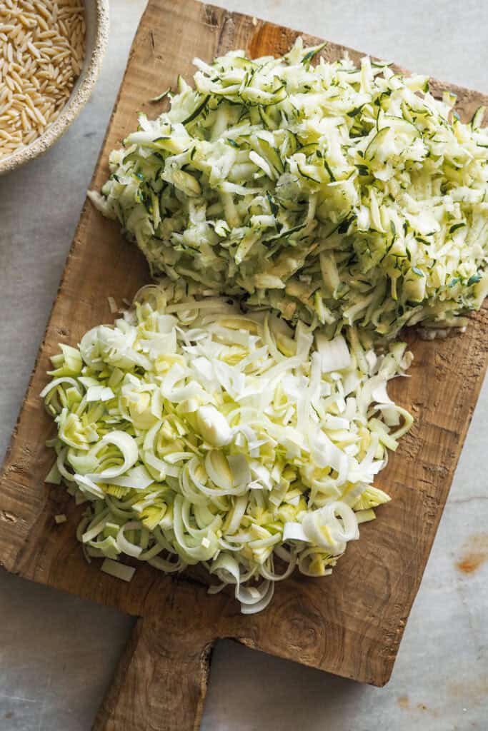 Calabacín rallado y Puerro laminado sobre una tabla de madera