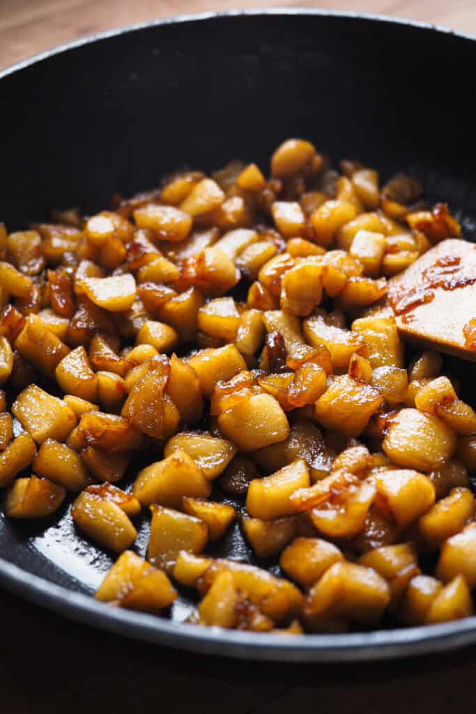 manzana caramelizada en una sartén para usar como Relleno de una trenza de hojaldre.
