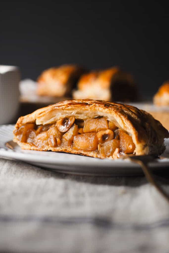 Hoy vamos con uno de esos postres fáciles y resultones que siempre te hacen quedar bien, una Trenza de Hojaldre Rellena de Manzana con Crema Inglesa. El hojaldre va relleno con manzana ligeramente pochada (para que no quede dura en el poco tiempo de horno que necesita la trenza) y avellanas para un toque crujiente dentro del mismo relleno. Es un postre que puedes preparar con antelación y todo junto hace un combo espectacular. | Receta de Paula's Apron