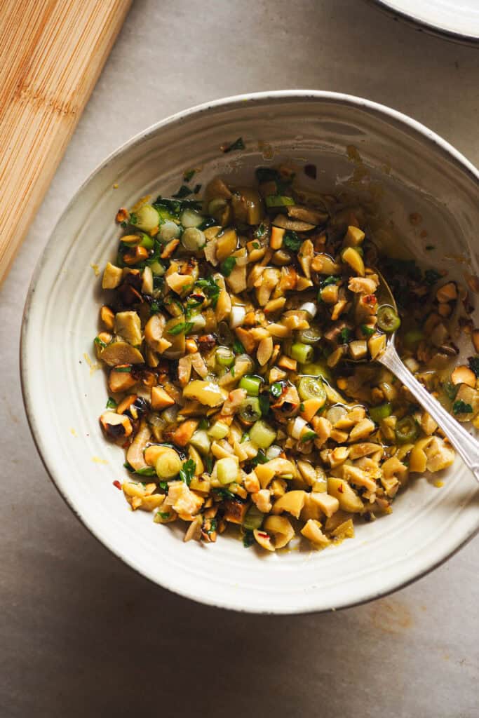 Aliño de aceitunas y pistachos para acompañar verduras y untables.