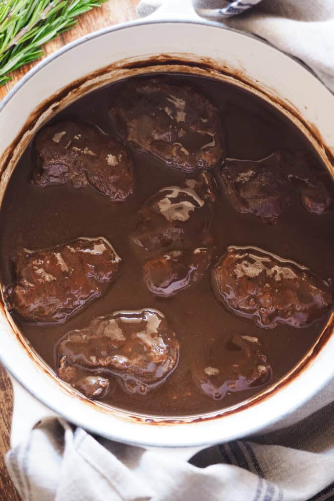 Mis recetas favoritas son sin duda las recetas tradicionales como esta, unas Carrilleras al Vino Tinto que te quitan el sentido y que harían orgullosa a mi abuela. Quedan melosas, tiernas y la salsa es de esas para mojar todo el pan del mundo, porque no querrás dejar ni una gota. Como buen guiso, requiere cariño y paciencia, pero con 4 pasos lo tienes, no pide más. Acompáñalas de puré de chirivía para una opción ligera, de polenta cremosa o el clásico puré de patatas y a desmayarte de placer cuando les pegues un bocado. | Receta de Paula's Apron