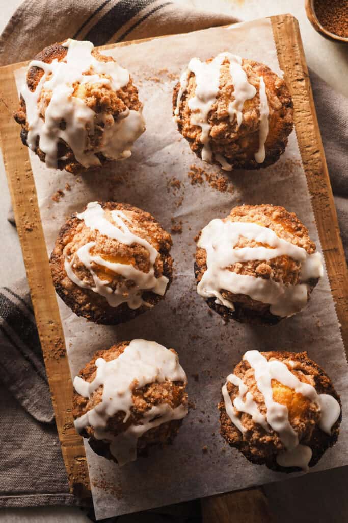 Si te encantan los cinnamon rolls pero no tienes tiempo para hacerlos, estas Cinnamon Roll Muffins son la solución. Combinan sus sabores y texturas pero en formato muffin, lo que te permite disfrutarlas en menos de 2 horas (vamos, en menos del tiempo de levado que necesitan los rollos de canela - sin tener en cuenta el resto del proceso). Miga húmeda y densa, con una capa interior de canela y para terminar un toque crujiente con un crumble (imitando el ligero toque crujiente acaramelado de la base de los rollos de canela) y el clásico glaseado. Simplemente perfectas para un día frío de otoño e invierno, ya sea para desayunar o merendar, tú eliges. | Receta de Paula's Apron