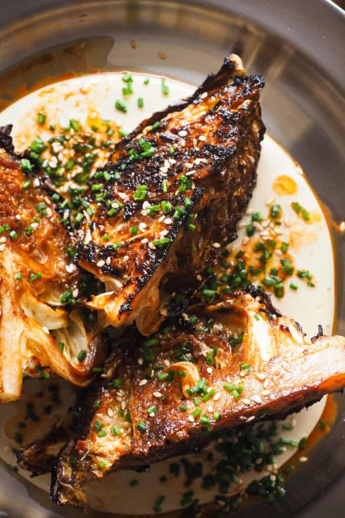 ¿Crees que no te gusta la col? Prepárate para cambiar de opinión con esta receta de Col al Horno con Miso y Crema de Anacardos, una nueva idea para transformar esta humilde verdura en un plato lleno de sabor. La col va asada con un toque umami de miso y acompañada de una base cremosa de anacardos que querrás usar con todo. Para rematar, un aliño ligeramente ácido que lo redondea todo, semillas de sésamo y cebollino. Es una receta fácil, saludable y simplemente deliciosa apta para veganos, celíacos e intolerantes a la lactosa. | Receta de Paula's Apron