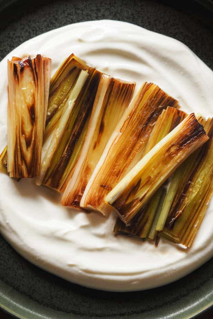 Puerros confitados sobre una base cremosa de queso fresco batido