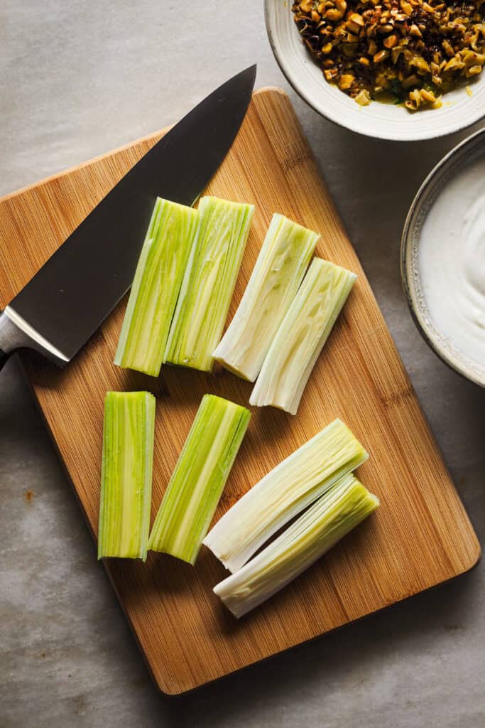 Puerros cortados por la mitad y en trozos sobre tabla de madera