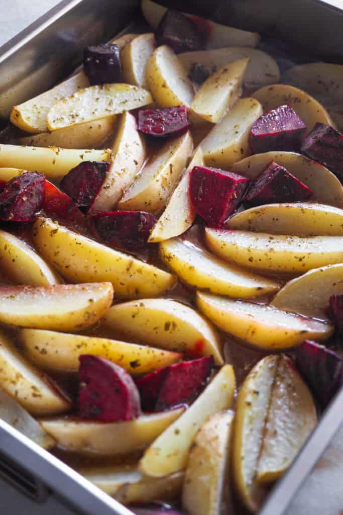 Patatas y Remolacha con el aderezo de pollo al limón al estilo griego, ya horneadas pero sin dorar.