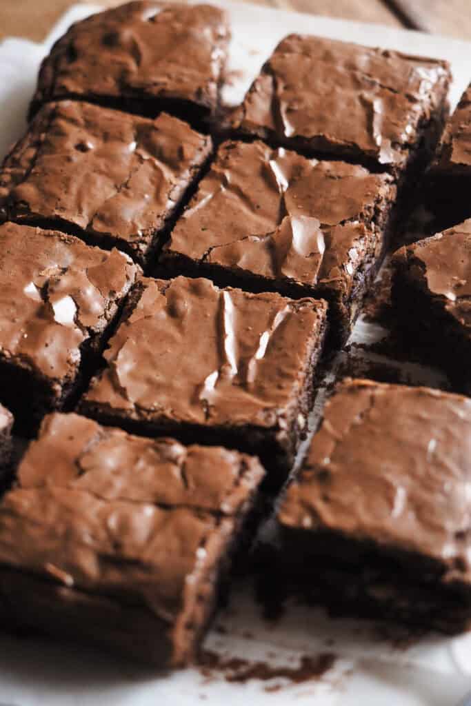 ¿En busca del brownie de chocolate perfecto? Después de semanas desarrollando esta receta, al fin te traigo la que para mi es la receta de brownie casero ideal. Tierno, pero sin ser abizcochado, húmedo y jugoso, pero ligero y suave a la vez, cero mazacote y con el punto de chocolate equilibrado para que no sea empalagoso. ¡Ah! Y con esa superficie brillante y quebradiza, ligeramente crujiente, que contrasta con la textura del interior, una mezcla perfecta entre "chewy" y "fudgy". Como toque final, y opcional, la cantidad justa de nueces para encontrarte un trocito aquí y allí pero sin que manden. ¡Ha sido la versión favorita entre todos mis amigos y familia, así que espero que te encante! | Receta de Paula's Apron