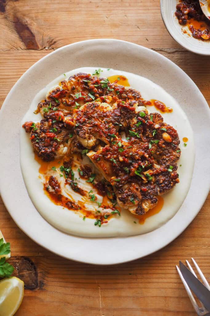 Convierte la infravalorada coliflor en un plato brutal con esta receta de Coliflor Braseada. Acompañada de un sofrito de tomate especiado con avellanas para textura y mi crema de chirivía y nabo como base, es un plato vegetal realmente sorprendente que puedes servir como entrante o principal (dependerá de la cantidad). Si tienes algún reticente de la coliflor a tu alrededor, ¡hazle cambiar de opinión con este recetón! | Receta de Paula's Apron