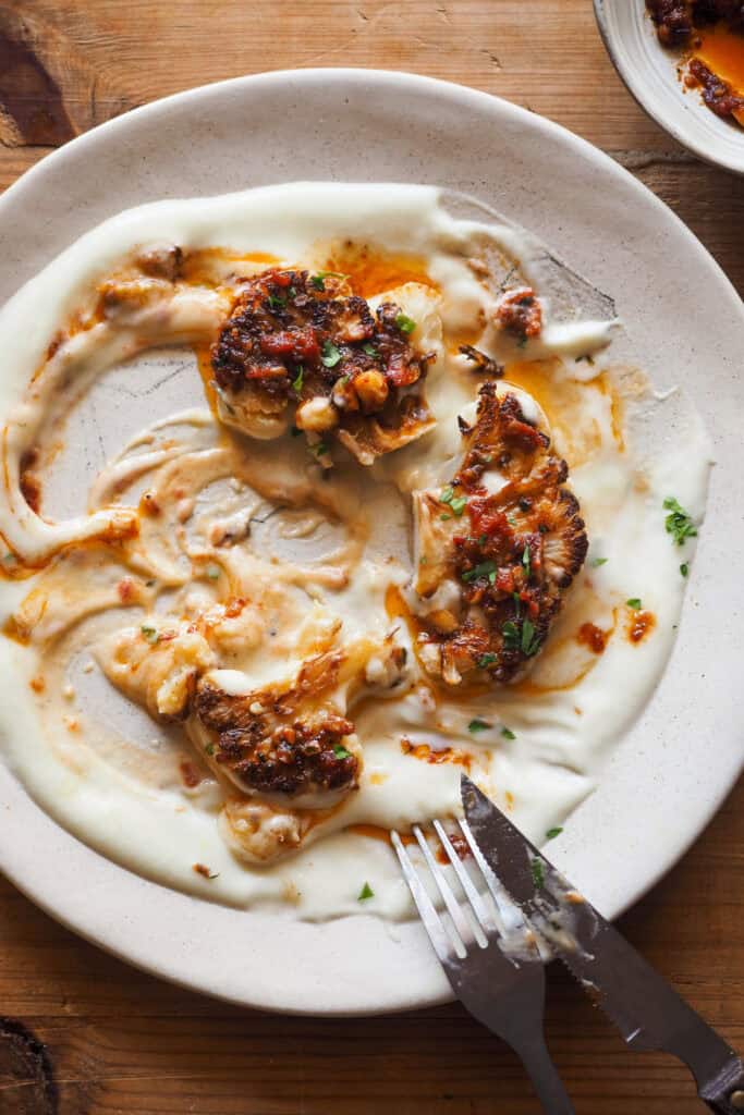 Convierte la infravalorada coliflor en un plato brutal con esta receta de Coliflor Braseada. Acompañada de un sofrito de tomate especiado con avellanas para textura y mi crema de chirivía y nabo como base, es un plato vegetal realmente sorprendente que puedes servir como entrante o principal (dependerá de la cantidad). Si tienes algún reticente de la coliflor a tu alrededor, ¡hazle cambiar de opinión con este recetón! | Receta de Paula's Apron