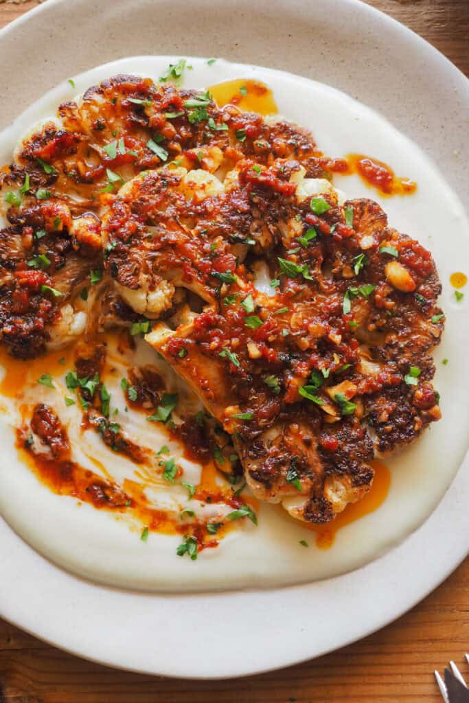 Convierte la infravalorada coliflor en un plato brutal con esta receta de Coliflor Braseada. Acompañada de un sofrito de tomate especiado con avellanas para textura y mi crema de chirivía y nabo como base, es un plato vegetal realmente sorprendente que puedes servir como entrante o principal (dependerá de la cantidad). Si tienes algún reticente de la coliflor a tu alrededor, ¡hazle cambiar de opinión con este recetón! | Receta de Paula's Apron