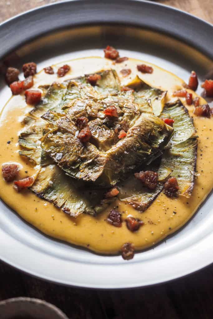 Si quieres impresionar en tu próxima comida o cena, esta Flor de Alcachofa a la Carbonara es lo que buscas. Nacida de unir dos de mis cosas favoritas en el mundo, la alcachofa y una salsa típica romana que no puede quedar relegada sólo a la pasta, el resultado es un plato sabroso, vistoso ¡y que parece de restaurante! | Receta de Paula's Apron