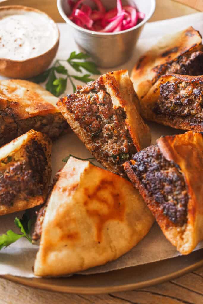 Este ha sido el último hit en casa, ¡los Arayes! Pita rellena de carne especiada y marcada a la plancha o asada en una barbacoa o al horno hasta que el relleno queda jugoso y al punto y el pan crujiente. Los puedes disfrutar como plato principal en una comida o cena o bien como aperitivo para compartir. Los comas cuando los comas, lo que es obligatorio es acompañarlos con la salsa de yogur y tahini que te voy a compartir. | Receta de Paula's Apron