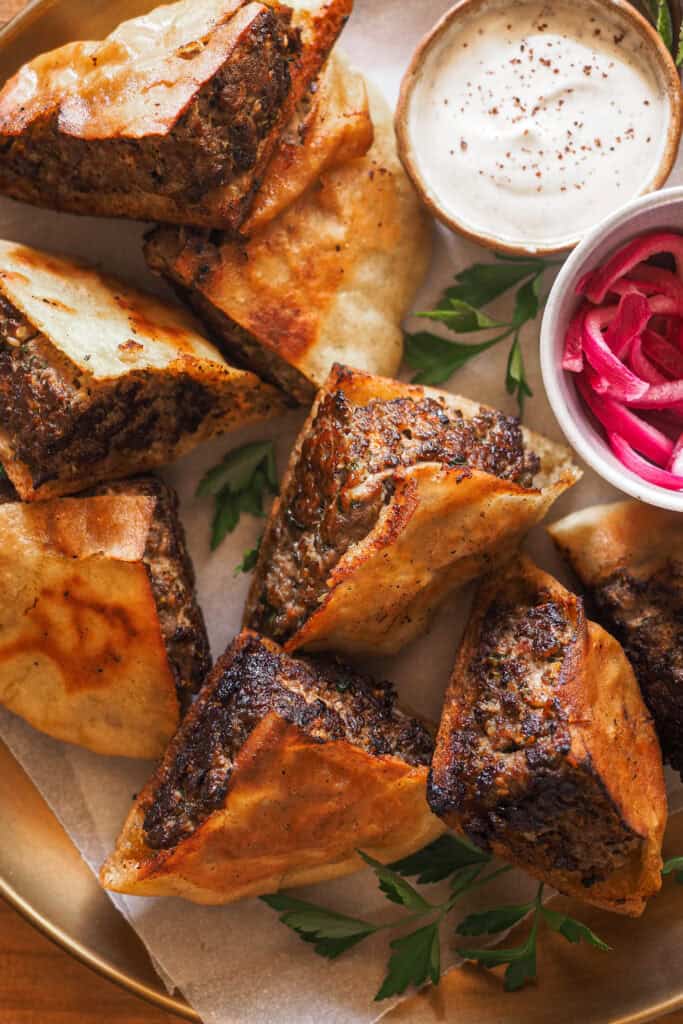 Este ha sido el último hit en casa, ¡los Arayes! Pita rellena de carne especiada y marcada a la plancha o asada en una barbacoa o al horno hasta que el relleno queda jugoso y al punto y el pan crujiente. Los puedes disfrutar como plato principal en una comida o cena o bien como aperitivo para compartir. Los comas cuando los comas, lo que es obligatorio es acompañarlos con la salsa de yogur y tahini que te voy a compartir. | Receta de Paula's Apron