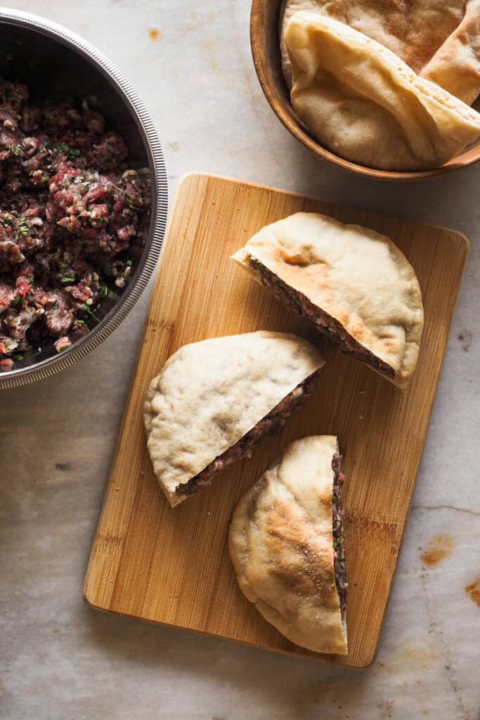 Pan pita partido por la mitad relleno de carne especiada para hacer arayes.