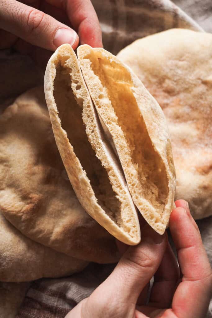 Hacer Pan Pita casero no puede ser más sencillo, increíble pero real. Queda tierno, suave y, lo más importante, hueco sin necesidad de complicarnos. Puedes preparar la masa el día de antes y dejarla levar en nevera toda la noche si quieres, así solo te quedará formar las porciones al día siguiente y en 2 minutos de horno conseguir globos de pan perfectos. El resultado no tiene comparación con ningún pan pita de supermercado, te lo aseguro (y si alguno no se te hincha. queda mejor casero ¡igualmente! El sabor es incomparable al de las versiones industriales). | Receta de Paula's Apron