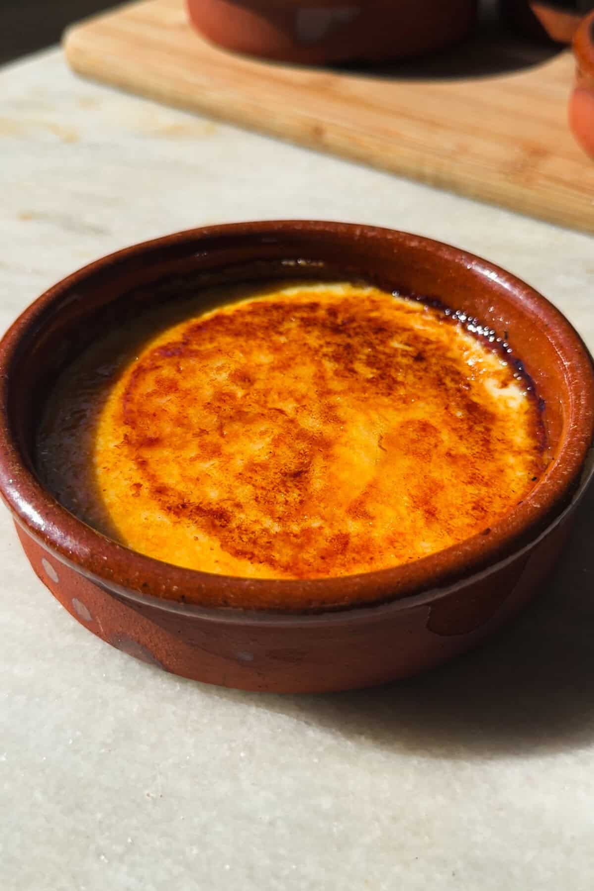 La Crema Catalana es uno de los postres tradicionales que no pueden faltar en tu repertorio porque como hecha en casa no hay nada. Es fácil y rápida de preparar, aunque sí que es verdad que luego tienes que esperarte antes de saborearla para que se asiente y coja cuerpo (lo único difícil de este postre :P). Sírvela con azúcar quemado si te gusta el contraste entre la capa de caramelo crujiente y el interior suave, o sin él al gusto (te confieso que yo soy de crema catalana sin quemar, ¡lo he dicho!). La sirvas como la sirvas, esta crema catalana de mi abuela es siempre un éxito. | Receta de Paula's Apron