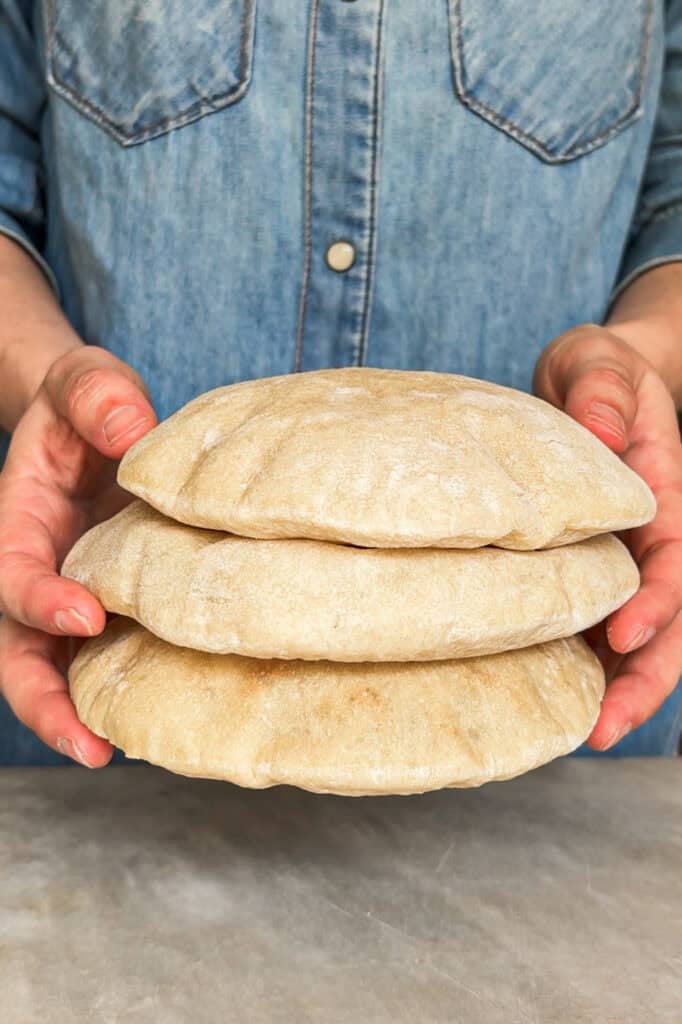 Hacer Pan Pita casero no puede ser más sencillo, increíble pero real. Queda tierno, suave y, lo más importante, hueco sin necesidad de complicarnos. Puedes preparar la masa el día de antes y dejarla levar en nevera toda la noche si quieres, así solo te quedará formar las porciones al día siguiente y en 2 minutos de horno conseguir globos de pan perfectos. El resultado no tiene comparación con ningún pan pita de supermercado, te lo aseguro (y si alguno no se te hincha. queda mejor casero ¡igualmente! El sabor es incomparable al de las versiones industriales). | Receta de Paula's Apron