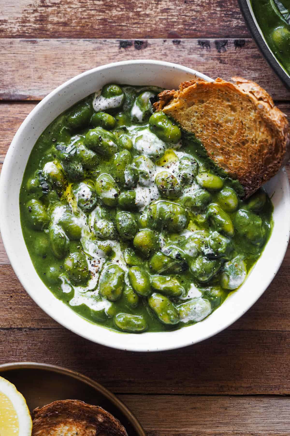 Estas Alubias con Salsa Cremosa de Espinacas son el típico plato que te puedes cocinar cualquier día para comer o cenar cuando quieras algo rápido, fácil y nutritivo sin escatimar en sabor. Es muy versátil además, pudiendo variar la salsa añadiendo verduras según lo que te de la temporada. También lleva leche de coco y albahaca para un toque aromático, lo que le da un aire ligeramente exótico, pero se puede usar tranquilamente nata u omitirla y jugar con las hierbas. Acompaña el plato con proteína extra al gusto, con pan y/o con algún cereal como el arroz y a disfrutar. | Receta de Paula's Apron