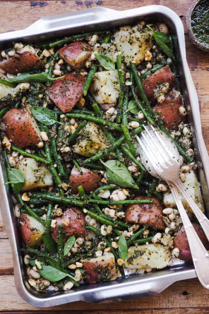 Creo que todos hemos sobrevivido a los veranos con ensaladas de patata, pero hacerla siempre igual me aborrece de mala manera así que hoy te traigo una idea brutal para variar, Ensalada de Judías Verdes y Patata con Alubias y Pesto. Y sí, está inspirada en otro clásico, las judías verdes con patata, pero adaptada para convertirla en una ensalada perfecta para llevarte en un tupper donde sea esta temporada (playa, piscina, río...). La alubia aporta proteína y otra textura y el pesto (que no es el tradicional ;) ) le da ese punto aromático y fresco que lo liga todo. Esta ensalada hará que un plan de verano bueno sea aún mejor :P. | Receta de Paula's Apron