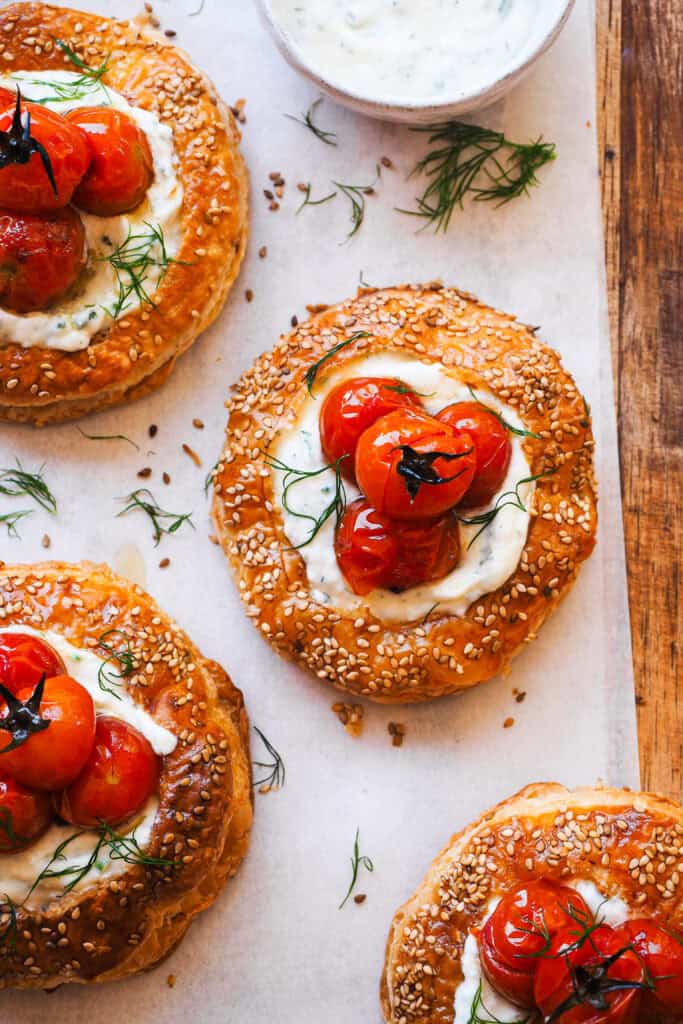 Nueva idea veraniega, que no falla y donde el protagonista son los tomates: Tartaletas de Tomate y Queso Feta. Son muy fáciles de hacer y con esta presentación siempre asombran. Uso tomates confitados pero puedes usar asados o frescos al gusto, estos van sobre una base crujiente y hojaldrada, con una crema de queso feta y mascarpone aromatizada con hierbas frescas que les va de maravilla. Son un entrante ideal con un poco de ensalada por ejemplo, absolutamente delicioso y perfecto para aprovechar el mejor momento del tomate y celebrar lo sencillo y lo bueno del verano. | Receta de Paula's Apron